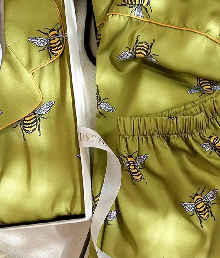 Green outfit with bee patterns in a box, featuring cartoon printing.