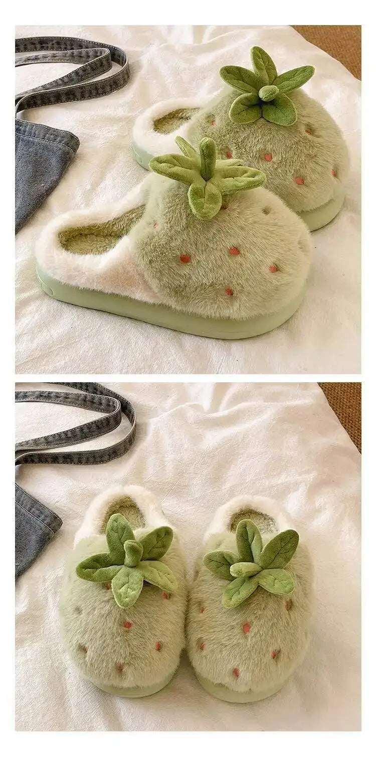 Pair of green slippers with strawberry design on a white surface