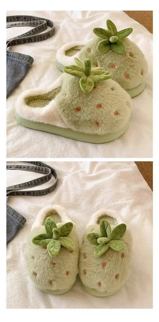 Pair of green slippers with strawberry design on a white surface