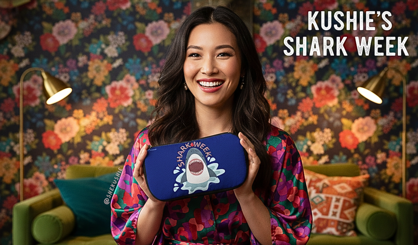 Woman holding a blue shark-themed product with colorful floral background and 'Kushie's Shark Week' text.