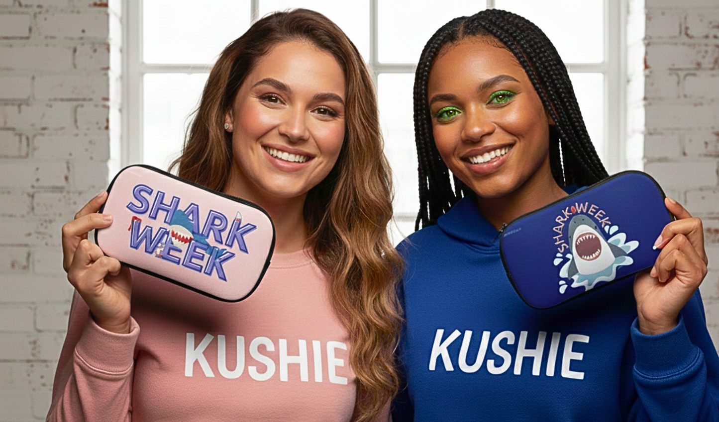 Two women holding Kushie products with 'Shark Week' branding.